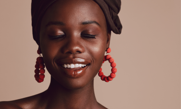 Woman smiling, eyes closed, round orange beaded earings